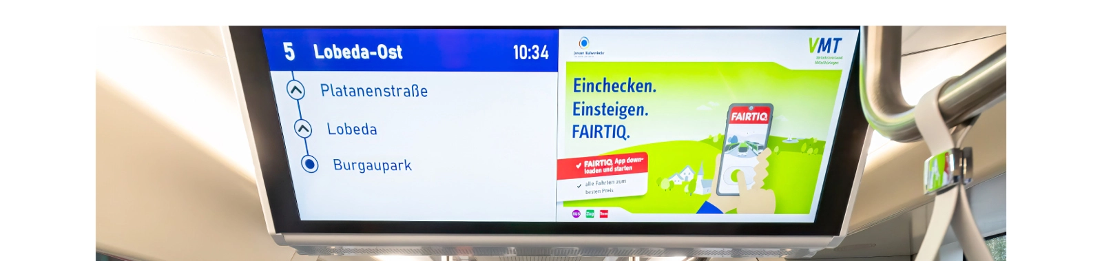 Foto von einem Monitor mit Werbung in einer Bahn.