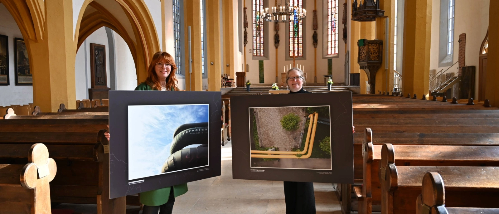 Ulrike Heyde von den Stadtwerken Energie (links) und Anya Schwammberger vom Team Stadtentwicklung geben mit zwei Bildern der Ausstellung „Best of Adern von Jena“ einen Vorgeschmack auf überraschende Perspektiven auf die Wärmeadern der Stadt.