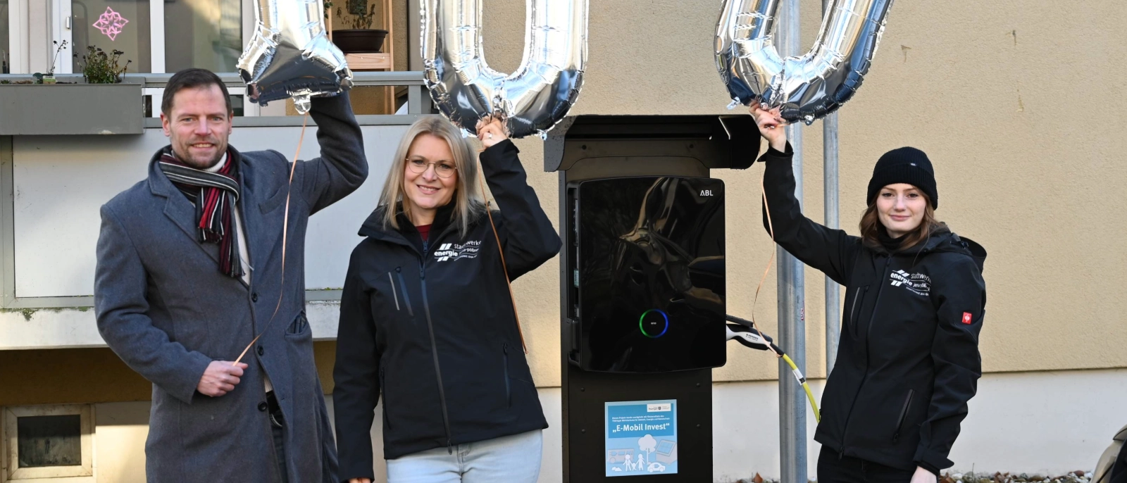 Ortsteilbürgermeister Bastian Stein freut sich gemeinsam mit Djamila Neutert und Laura Auerbach-Gottschall von den Stadtwerken Energie über die 100. öffentliche Ladesäule in Jena (v.l.n.r.).