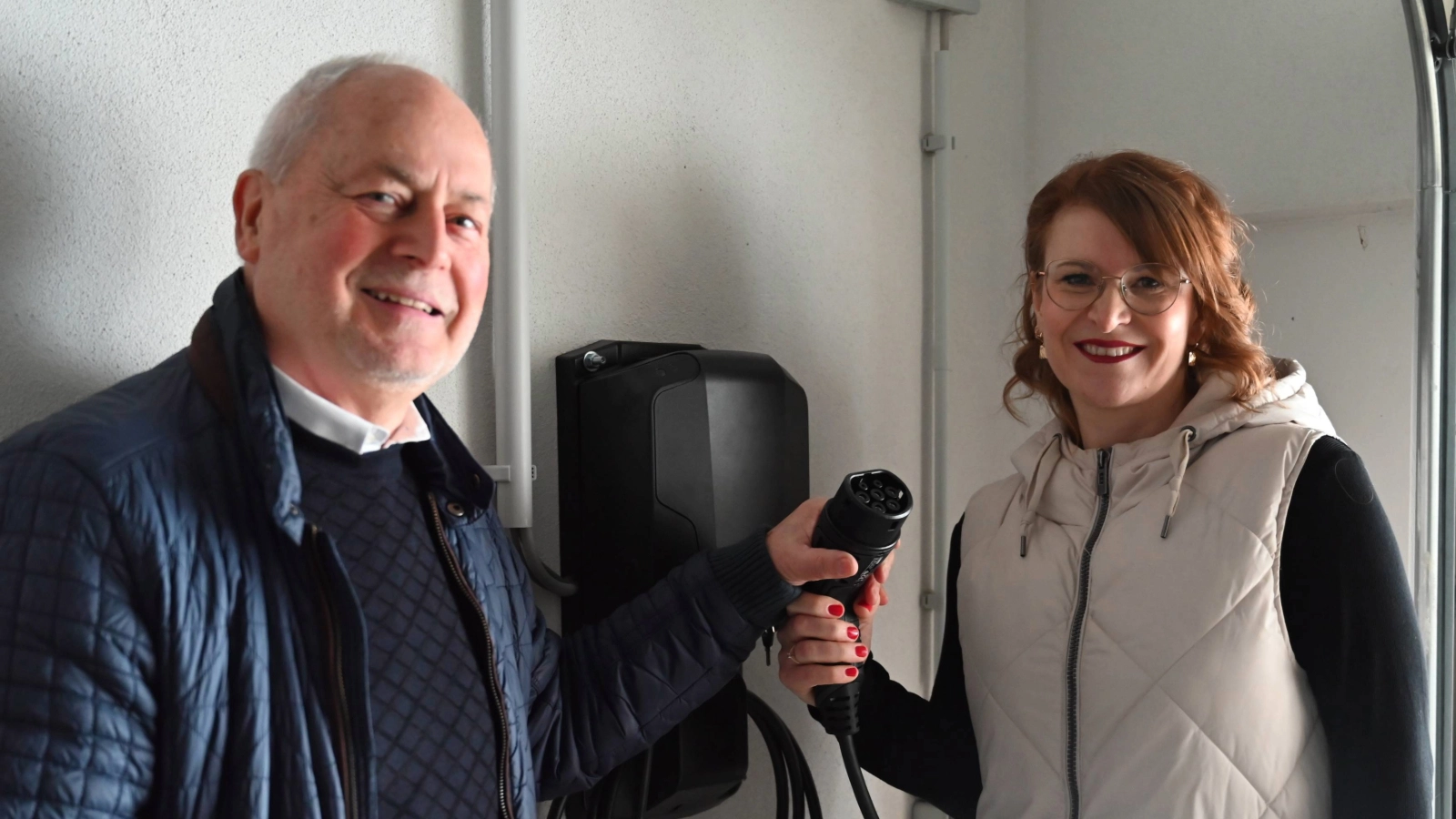 Djamila Neutert, Teamleiterin Energiedienstleistungen bei den Stadtwerken Energie, und Hausverwalter Rainer Raithel bei der Übergabe der Wallboxen.  