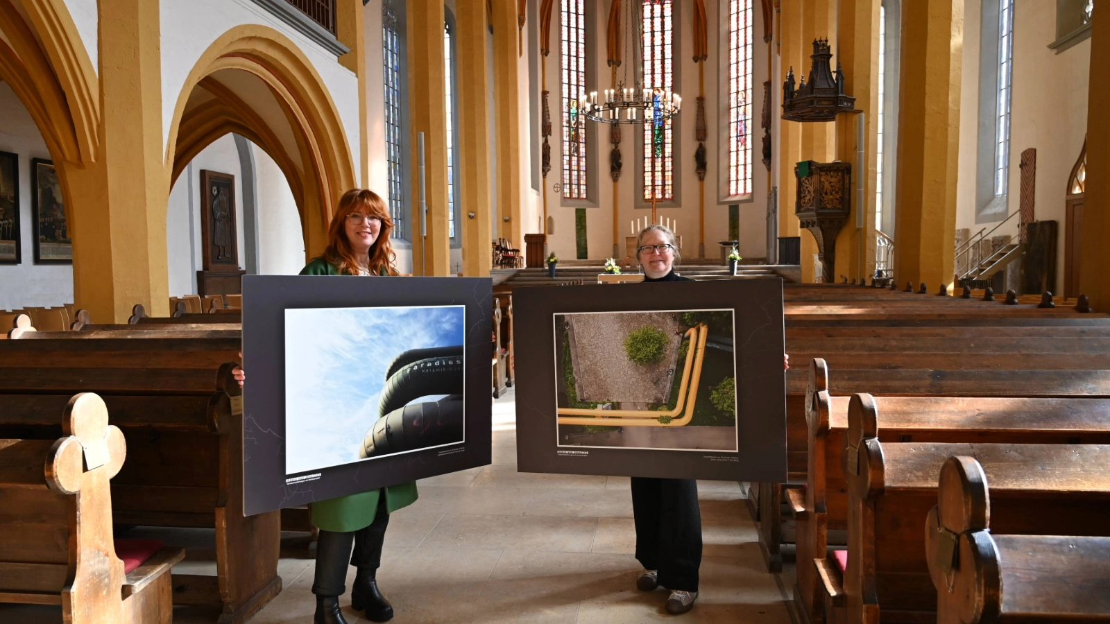 Ulrike Heyde von den Stadtwerken Energie (links) und Anya Schwammberger vom Team Stadtentwicklung geben mit zwei Bildern der Ausstellung „Best of Adern von Jena“ einen Vorgeschmack auf überraschende Perspektiven auf die Wärmeadern der Stadt.