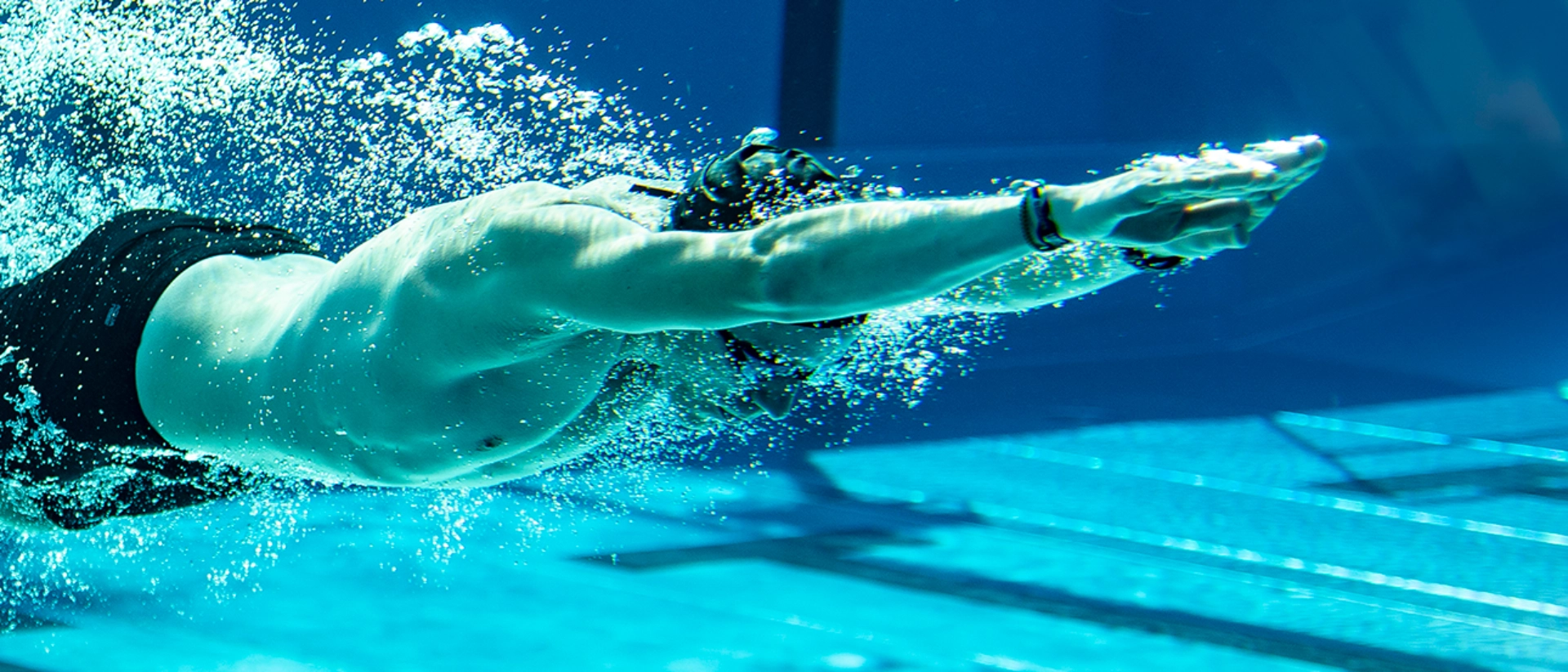 Ein Mann taucht in ein Schwimmbecken ein