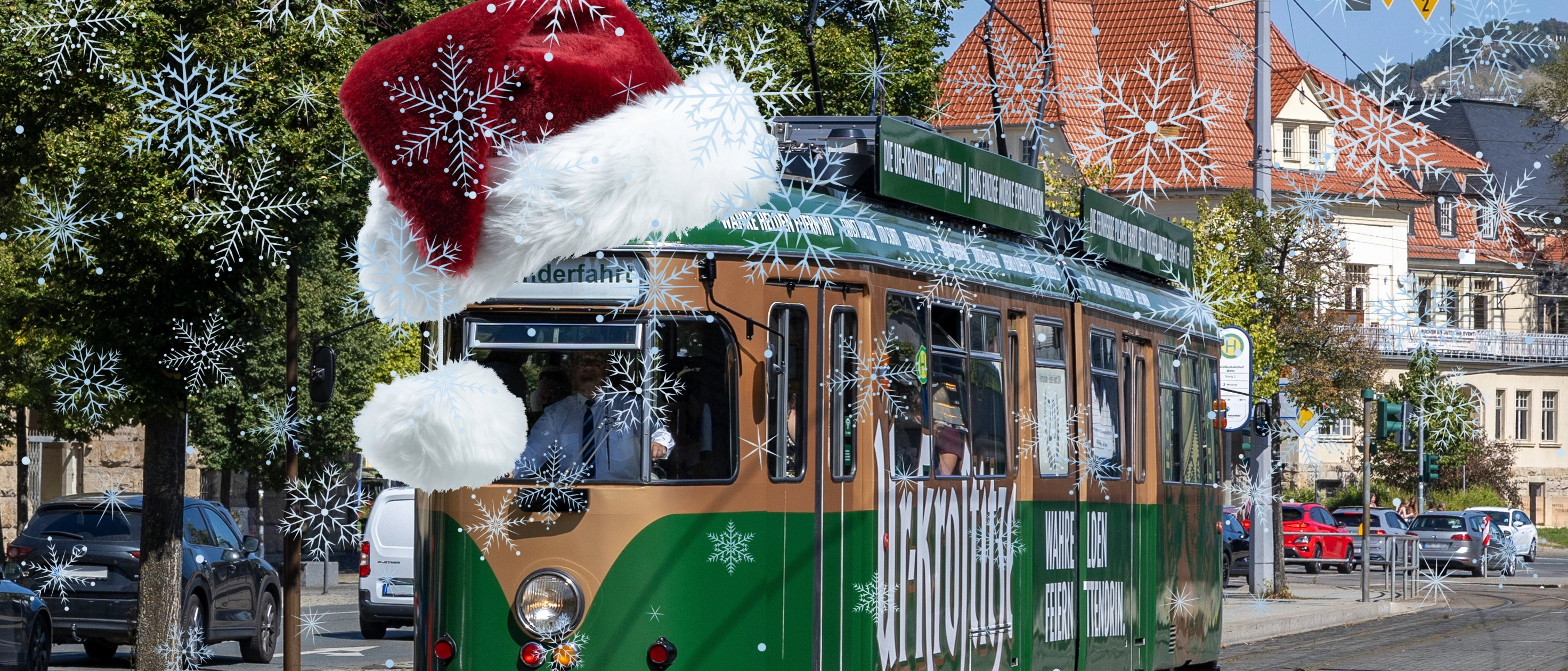 Die Partybahn im Stadtgebiet mit einer Weihnachtsmütze und Schneeflocken.