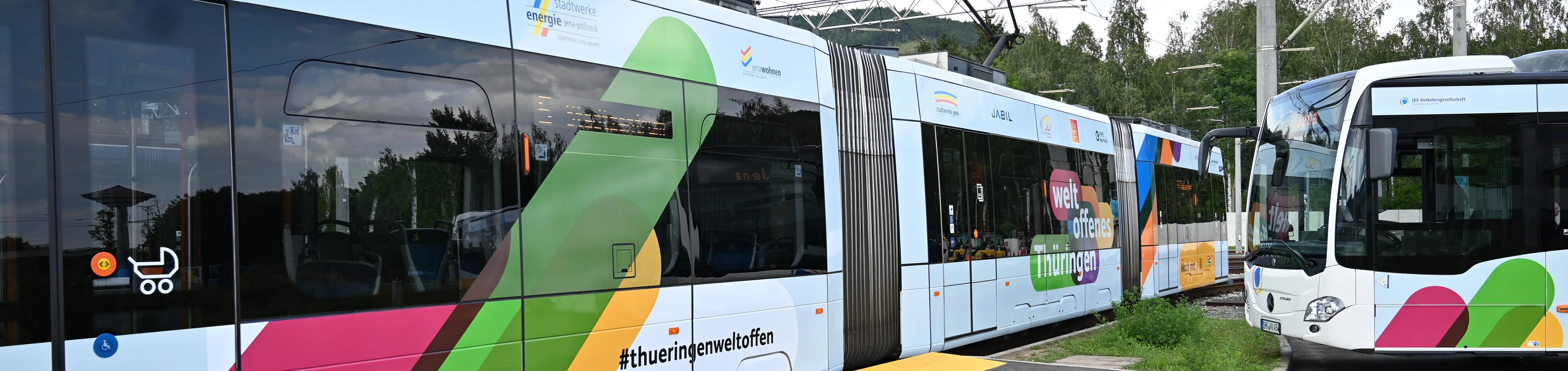 Ein Bus und eine Straßenbahn mit einer Weltoffenes Thüringen-Beklebung