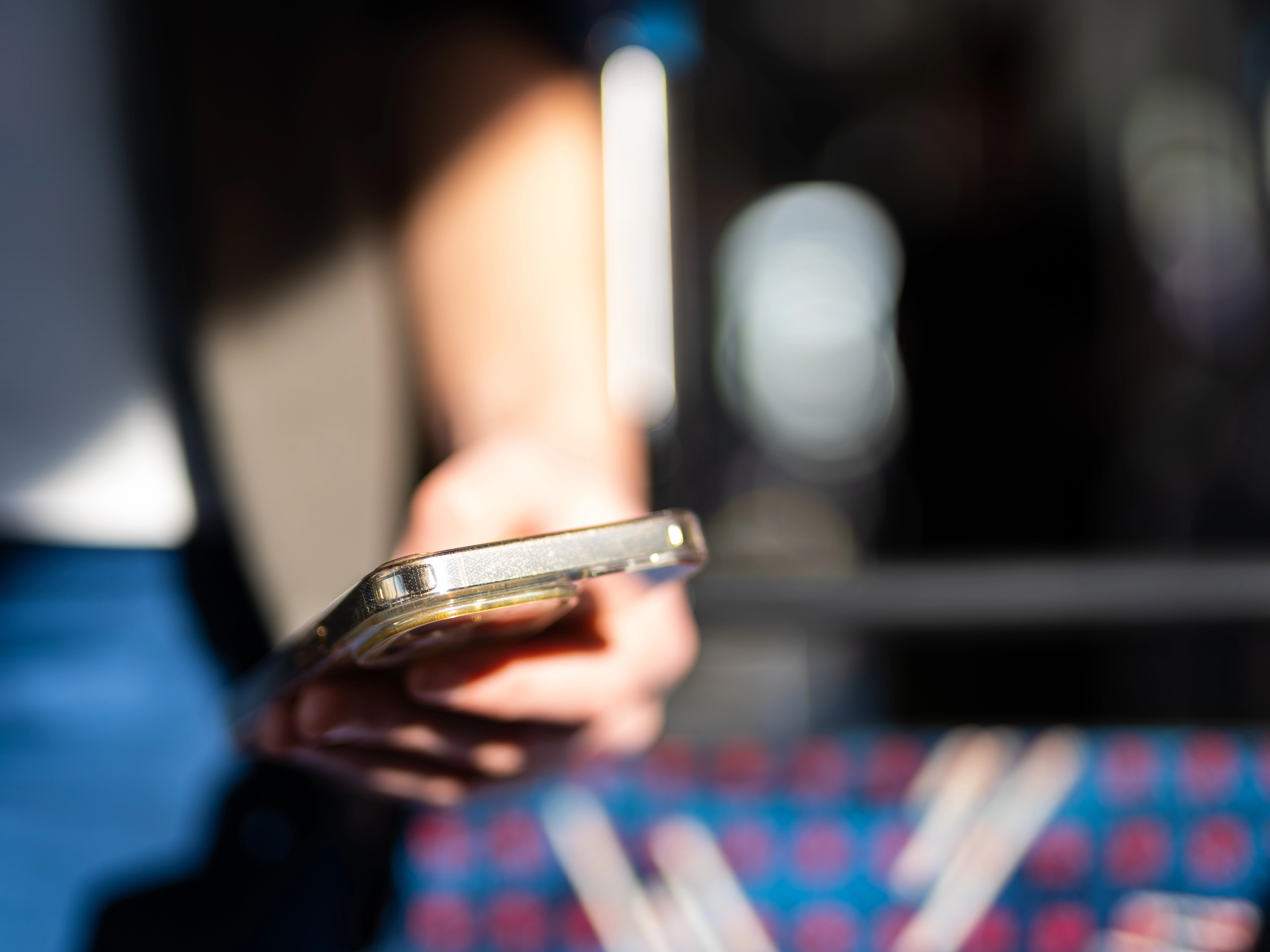 Nahaufnahme von jemandem, der im Bus ein Handy in der Hand hält.